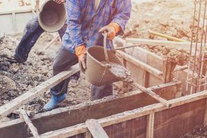 man worker mixing cement mortar plaster for construction with vintage tone. photo