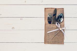 Christmas table place setting and silverware on wood with space and Table setting on wood background vintage. photo