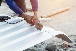 construction worker cutting roof for building photo