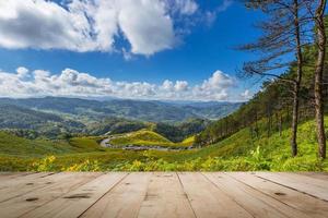 Wood table and Tung Bua Tong Mexican sunflower in Maehongson, Thailand photo