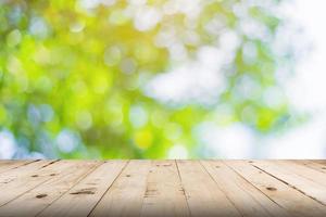 green leaf bokeh blurred and wood table for nature background photo