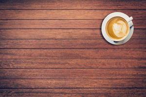 coffee cup on wood old wood table with space, vintage filter. photo