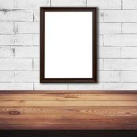 frame picture on white brick wall and wood table background texture with space photo