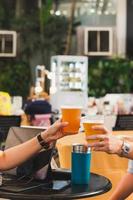 Couple hands holding glasses of beer toasting. photo