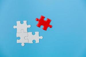 White and red jigsaw puzzle on a blue background. Copy space for text, top view, close up. photo