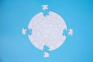 White jigsaw puzzle pieces on a blue background. Problem solving concepts. Texture photo with copy space for text