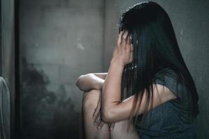 Young depressed woman, domestic and rape violence,beaten and raped sitting in the corner,  Copy space.  International Women's Day photo