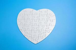 White jigsaw puzzle pieces on a blue background. Problem solving concepts. Texture photo with copy space for text