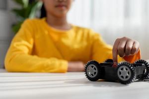 los estudiantes de asia aprenden en casa a codificar autos robot y cables de tableros electrónicos en tallo, vapor, ingeniería matemática, ciencia, tecnología, código de computadora en robótica para el concepto de niños. foto