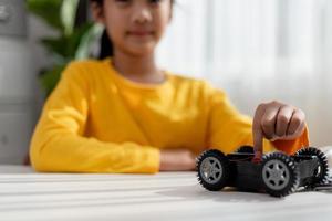 Asia students learn at home in coding robot cars and electronic board cables in STEM, STEAM, mathematics engineering science technology computer code in robotics for kids concept. photo