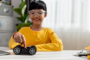 Asia students learn at home in coding robot cars and electronic board cables in STEM, STEAM, mathematics engineering science technology computer code in robotics for kids concept. photo