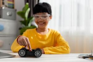 Asia students learn at home in coding robot cars and electronic board cables in STEM, STEAM, mathematics engineering science technology computer code in robotics for kids concept. photo