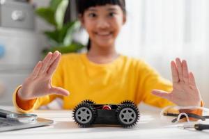 los estudiantes de asia aprenden en casa a codificar autos robot y cables de tableros electrónicos en tallo, vapor, ingeniería matemática, ciencia, tecnología, código de computadora en robótica para el concepto de niños. foto