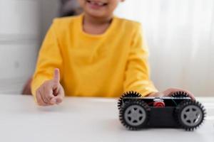 Asia students learn at home in coding robot cars and electronic board cables in STEM, STEAM, mathematics engineering science technology computer code in robotics for kids concept. photo