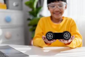 los estudiantes de asia aprenden en casa a codificar autos robot y cables de tableros electrónicos en tallo, vapor, ingeniería matemática, ciencia, tecnología, código de computadora en robótica para el concepto de niños. foto