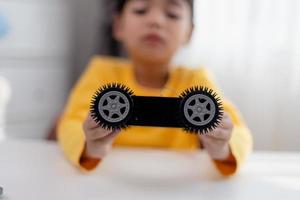 los estudiantes de asia aprenden en casa a codificar autos robot y cables de tableros electrónicos en tallo, vapor, ingeniería matemática, ciencia, tecnología, código de computadora en robótica para el concepto de niños. foto