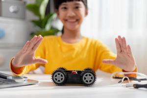 los estudiantes de asia aprenden en casa a codificar autos robot y cables de tableros electrónicos en tallo, vapor, ingeniería matemática, ciencia, tecnología, código de computadora en robótica para el concepto de niños. foto