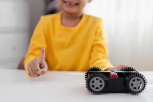 Asia students learn at home in coding robot cars and electronic board cables in STEM, STEAM, mathematics engineering science technology computer code in robotics for kids concept. photo