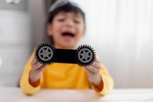 Asia students learn at home in coding robot cars and electronic board cables in STEM, STEAM, mathematics engineering science technology computer code in robotics for kids concept. photo