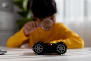 los estudiantes de asia aprenden en casa a codificar autos robot y cables de tableros electrónicos en tallo, vapor, ingeniería matemática, ciencia, tecnología, código de computadora en robótica para el concepto de niños. foto