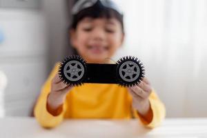 Asia students learn at home in coding robot cars and electronic board cables in STEM, STEAM, mathematics engineering science technology computer code in robotics for kids concept. photo