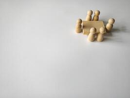 Wooden people figures having business meeting with customizable space for text. Copy space.