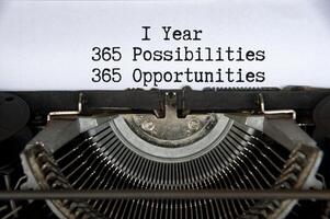 1 year 365 opportunities and opportunities words typed on an old vintage typewriter in black and white photo