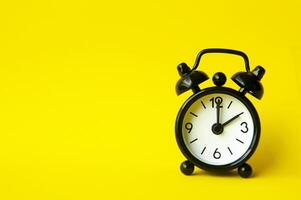 Alarm clock pointing at 2 am or pm with customizable space for text or ideas. Copy space with yellow background photo