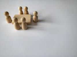 Wooden people figures having business meeting with customizable space for text. Business concept and copy space. photo