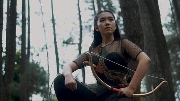vrouw boogschieten Holding een boog en een pijl in de oerwoud jacht- voor vijand video