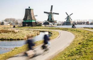 Dutch countryside with moving windmills and visitors in the area photo