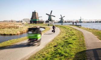 Dutch countryside with moving windmills and visitors in the area photo