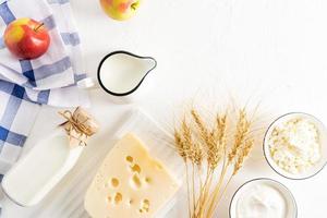 Jewish holiday Shavuot concept with dairy products, fruits, cheese, milk bottle on white table. Flat lay, top view. photo