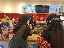 Magelang,INDONESIA ,2023.female buyer wearing a hijab is buying an ice cone and is at the cashier. photo