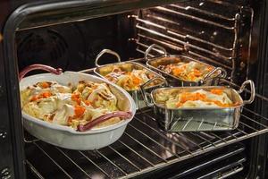 repollo rollos con salmón, zanahorias y salsa son horneado en el horno. francés receta foto