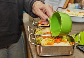 Chef pours sauce on cabbage rolls with salmon, carrots in the kitchen. French recipe photo