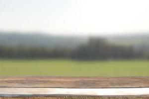 Wooden rustic table top on blurred greenery background photo