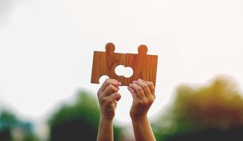 jigsaw and hands Combine the power of unity, teamwork, teamwork. photo