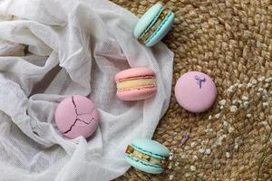 pink and mint french macaroons or macarons cookies and a white flowers on a cloth background. Natural fruit and berry flavors, creamy stuffing for valentines mother day easter with love food photo