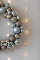 Christmas wreath of blue and white balls on wooden white surface. Top view, horizontal. For background or greeting card. photo