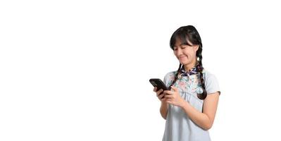 Portrait of happy beautiful young asian woman in denim dress using a smartphone on white background. studio shot photo
