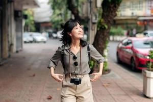 joven asiático mujer mochila viajero disfrutando calle cultural local sitio y sonrisa. foto