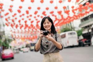 Young Asian woman backpack traveler enjoying China town street food market in Bangkok, Thailand. Traveler checking out side streets. photo