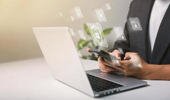 A businessman works on his laptop at home with a virtual display showing a symbol to signify cyber security privacy and online data protection photo