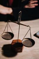 Justice and law concept.Male judge in a courtroom with the gavel, working with, computer and docking keyboard, eyeglasses, on table in morning light photo