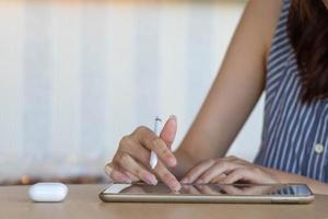 Young woman holding a stylus in her hand to use along with application in tablet to test and develop ux ui system and to design application that can work efficiently with perfect ux ui system. photo