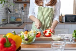 A young woman prepares bell peppers for her breakfast and is ready for a healthy meal on the table with healthy, organic vegetables on the table. healthy food preparation ideas photo