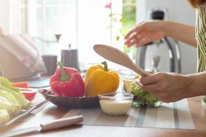 young woman preparing bell Pepper as a breakfast ingredient and ready for healthy cooking and on the table there are vegetables that are healthy organic ingredients. healthy food preparation ideas photo