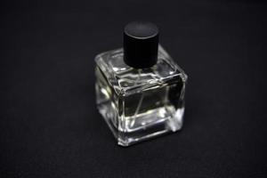 A glass perfume bottle on a black background. A bottle of perfume in close-up. Perfumery. photo