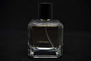 A glass perfume bottle on a black background. A bottle of perfume in close-up. Perfumery. photo